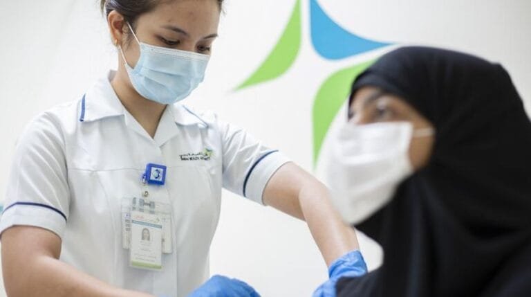 a_medical_worker_injects_a_dose_of_a_vaccine_against_the_coronavirus_disease_covid-19_to_a_woman_in_dubai_uae_december_23_2020._government_of_dubai_media_office_via_reuters.jpg