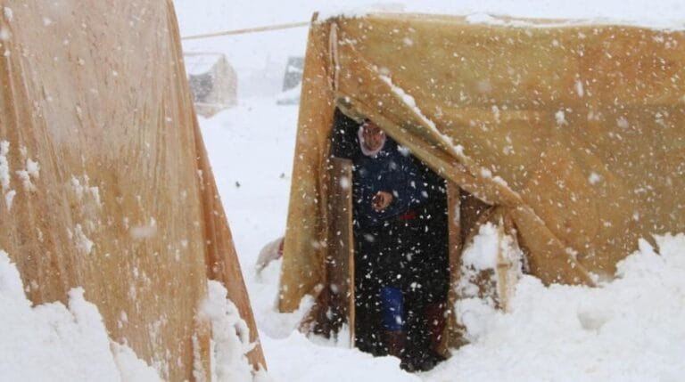 a_syrian_refugee_stands_at_the_entrance_of_her_tent_during_a_snow_storm_at_an_unofficial_camp_on_the_road_between_riyaq_and_baalbek_in_lebanons_eastern_bekaa_valley._afp_file_photo.jpg